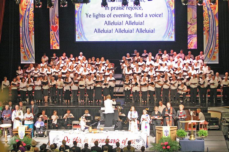 18 - Worship at Civic Center.jpg - At the San Jose Civic Center, Dr. Charlene Archibeque leads the choir in Sunday worship.  Alice Thorn (seated at left of the director) helps coordinate timing between the two services.  Many Stone Church members sung in the choir.